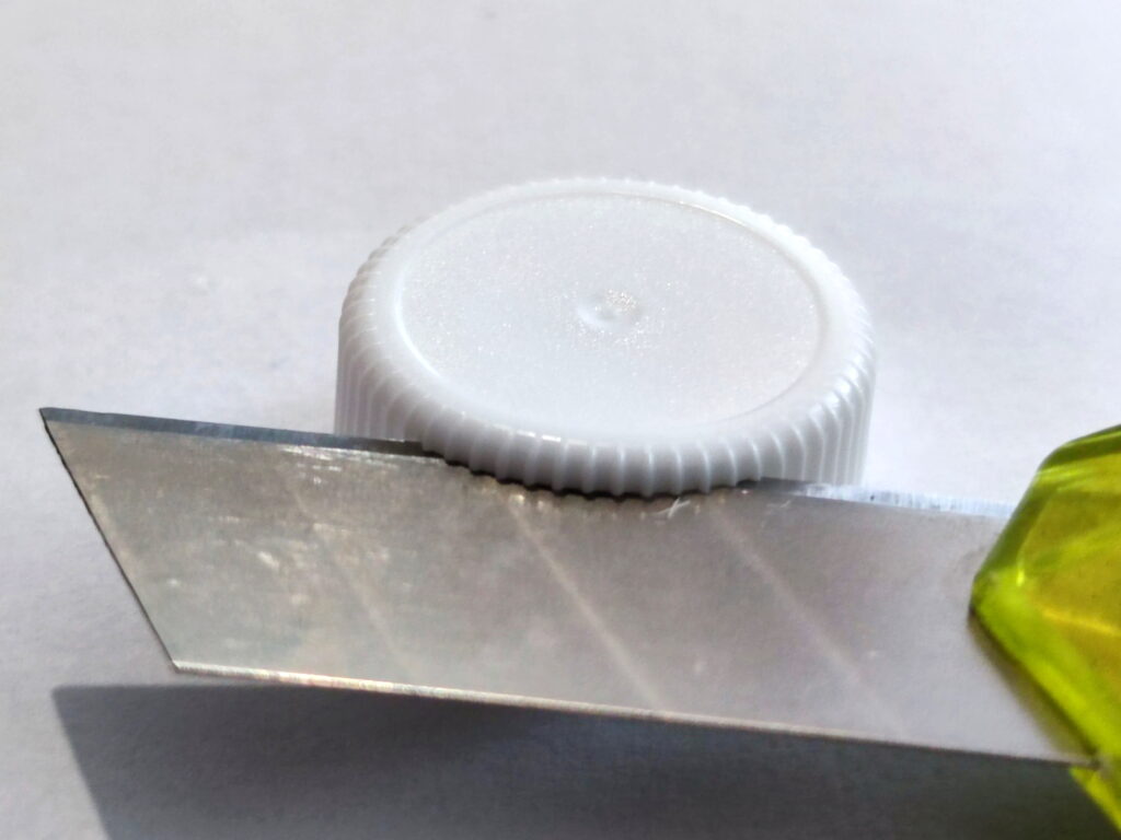 Plastové PET víčko obřežeme nožíkem z jeho vnější strany po celém jeho obvodu.